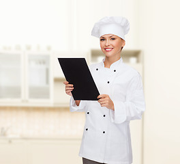 Image showing smiling female chef with black blank paper