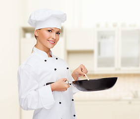 Image showing smiling female chef with pan and spoon