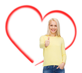 Image showing smiling girl in casual clothes showing thumbs up