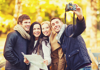 Image showing group of friends with photo camera in autumn park