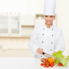 Image showing smiling female chef chopping vegetables