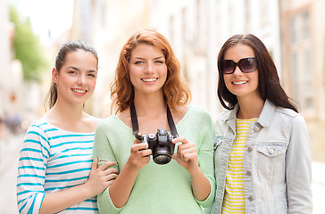 Image showing smiling teenage girls with camera