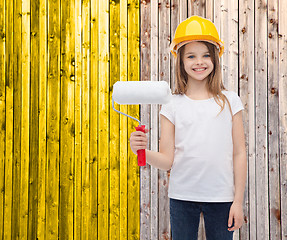 Image showing smiling little girl in helmet with paint roller