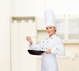 Image showing smiling female chef with pan and spoon