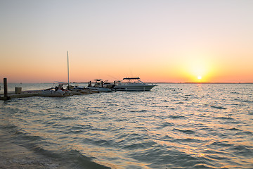 Image showing boats moored to pier at sundown