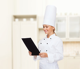 Image showing smiling female chef with black blank paper