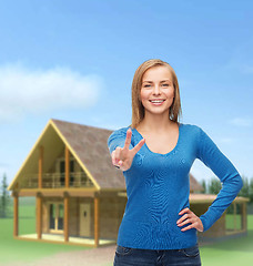 Image showing smiling teenage girl showing v-sign with hand