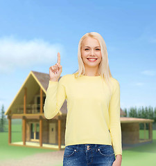 Image showing smiling woman pointing her finger up