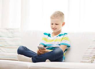 Image showing smiling little boy with smartphone at home