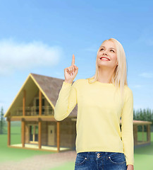 Image showing smiling woman pointing her finger up