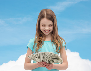 Image showing smiling little girl looking at dollar cash money