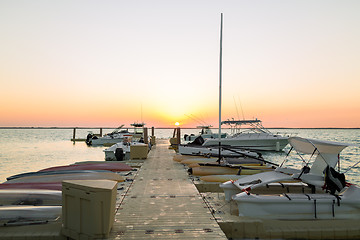 Image showing boats moored to pier at sundown