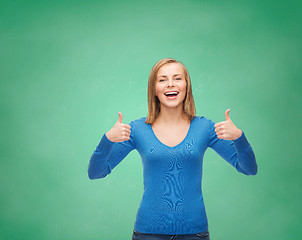 Image showing smiling girl in casual clothes showing thumbs up