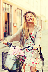 Image showing attractive woman in hat with bicycle in the city