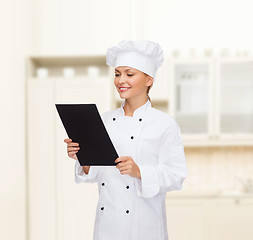 Image showing smiling female chef with black blank paper