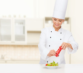 Image showing smiling female chef with preparing salad