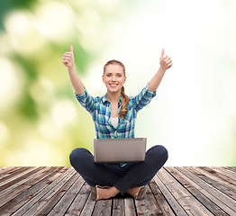 Image showing smiling woman with laptop and showing thumbs up