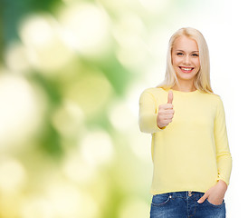 Image showing smiling girl in casual clothes showing thumbs up