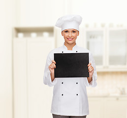 Image showing smiling female chef with black blank paper