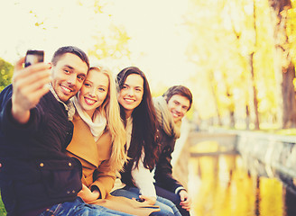 Image showing group of friends taking selfie in autumn park