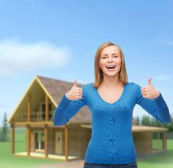 Image showing smiling girl in casual clothes showing thumbs up