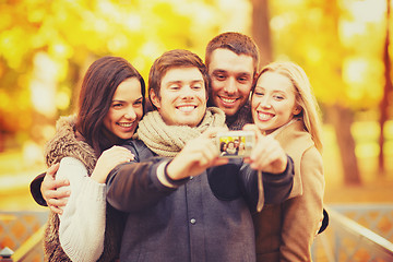 Image showing group of friends with photo camera in autumn park