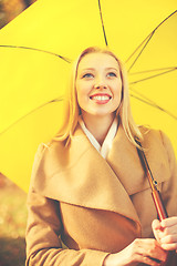 Image showing woman with yellow umbrella in the autumn park