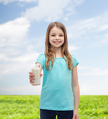 Image showing smiling little girl giving glass of milk