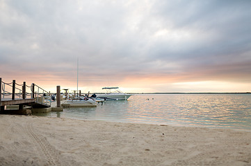 Image showing boats moored to pier at sundown