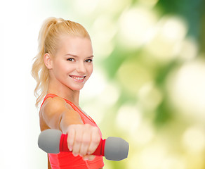 Image showing smiling beautiful sporty woman with dumbbell