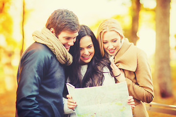 Image showing friends with tourist map in autumn park