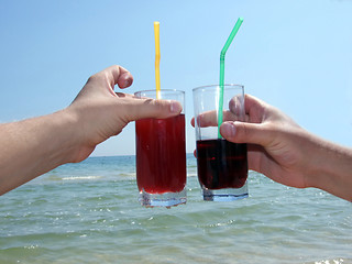 Image showing Two man's hands with glasses of cocktails on a background of the