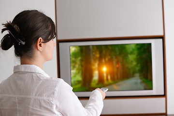 Image showing young woman watching tv at home