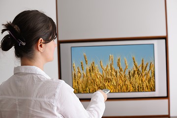 Image showing young woman watching tv at home