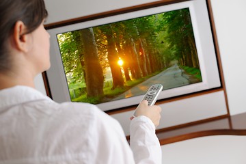 Image showing young woman watching tv at home