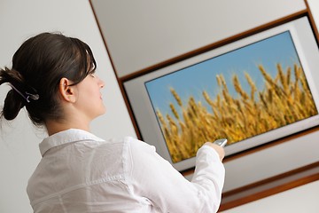 Image showing young woman watching tv at home