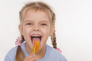 Image showing Funny girl licking a lollipop