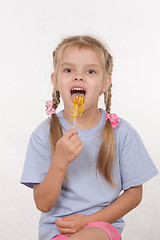 Image showing Five year old girl licking a lollipop