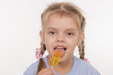 Image showing Girl licking a lollipop
