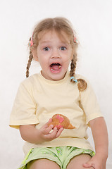 Image showing Fun girl opened her mouth while eating a muffin