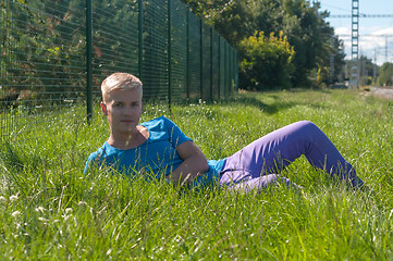 Image showing Young man lying on the green grass