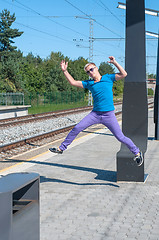 Image showing Handsome young guy jumping on train station