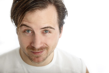 Image showing Attractive man in a white shirt looks into the camera