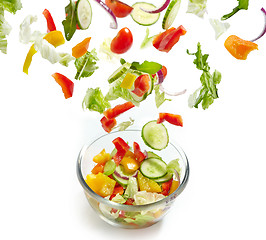 Image showing Fresh vegetables falling into the glass bowl