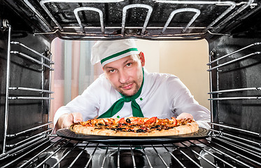 Image showing Chef cooking pizza in the oven.