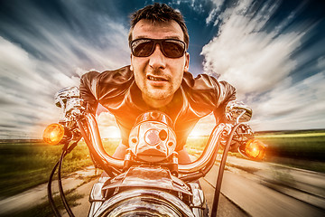 Image showing Biker racing on the road