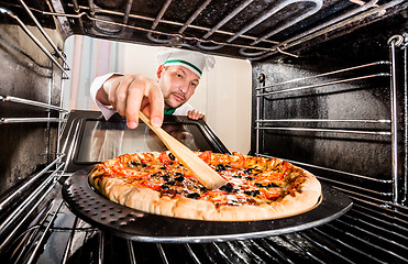 Image showing Chef cooking pizza in the oven.