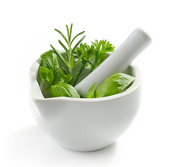 Image showing green herb leaves in a white pestle