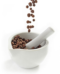 Image showing Black aromatic peppercorns falling into mortar and pestle