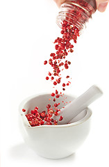 Image showing red peppercorns falling into mortar and pestle